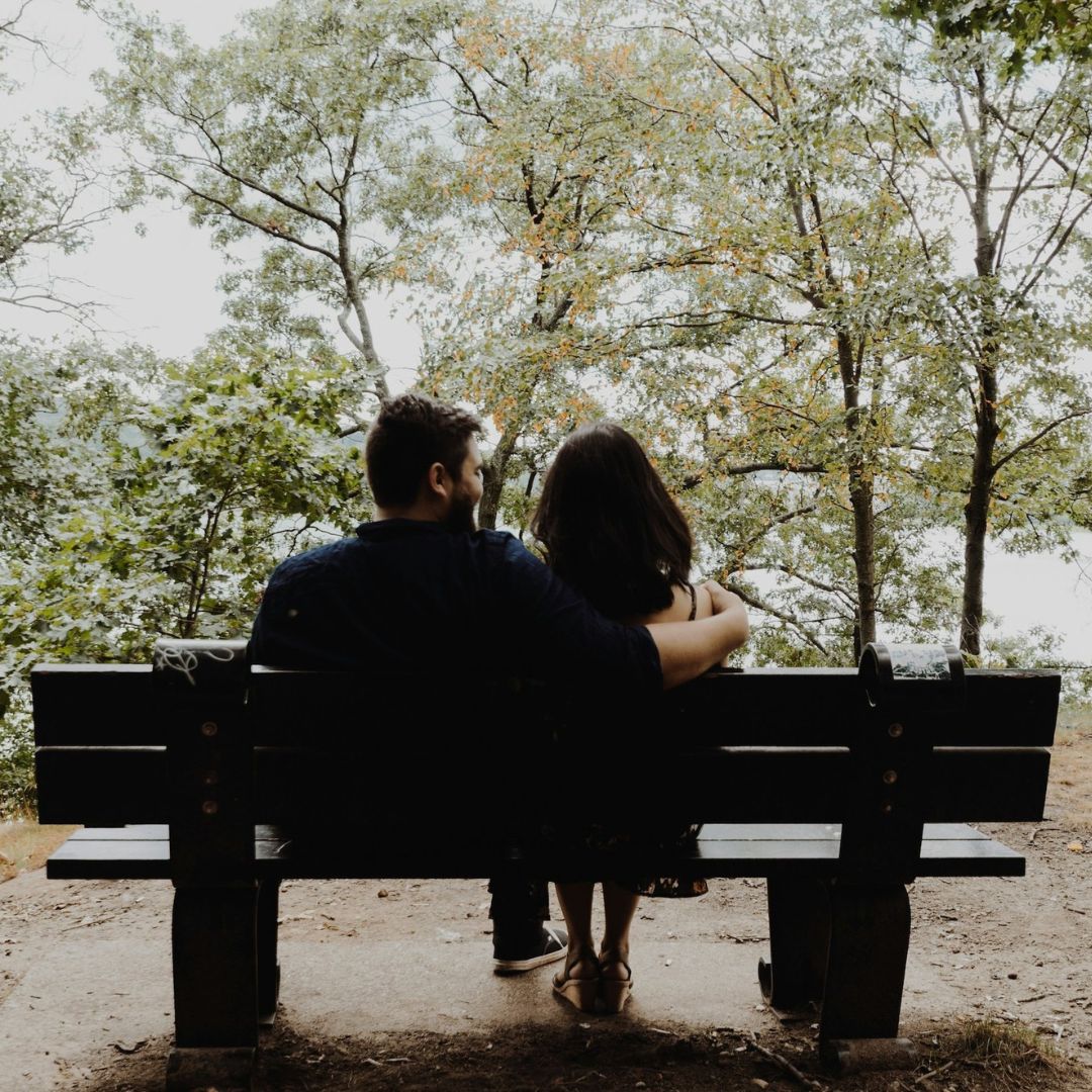 Couple sitting on park bench.